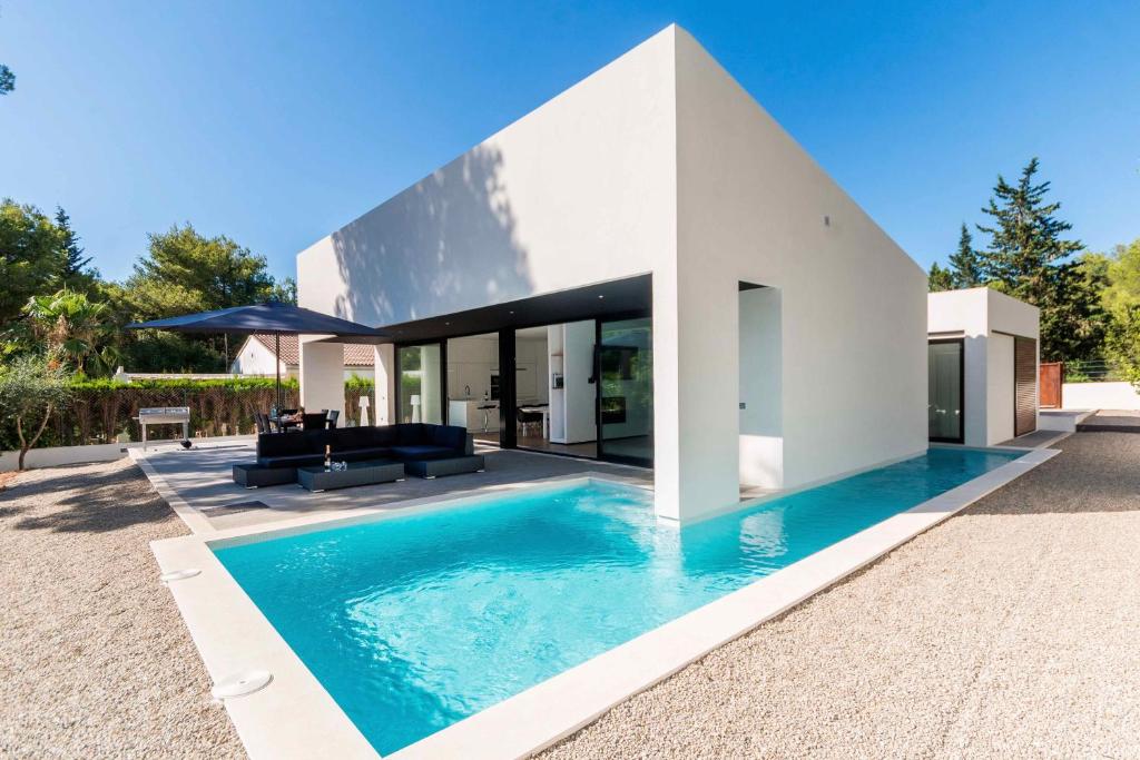 a house with a swimming pool in front of it at Ca Na Rosa - Modern Villa with Private Pool in Cielo de Bonaire 