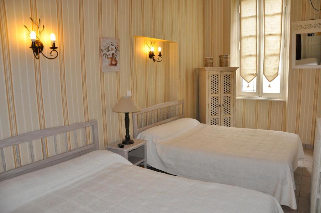 les deux acacias في Villepinte: غرفة نوم بسريرين ونافذة ومصباحين