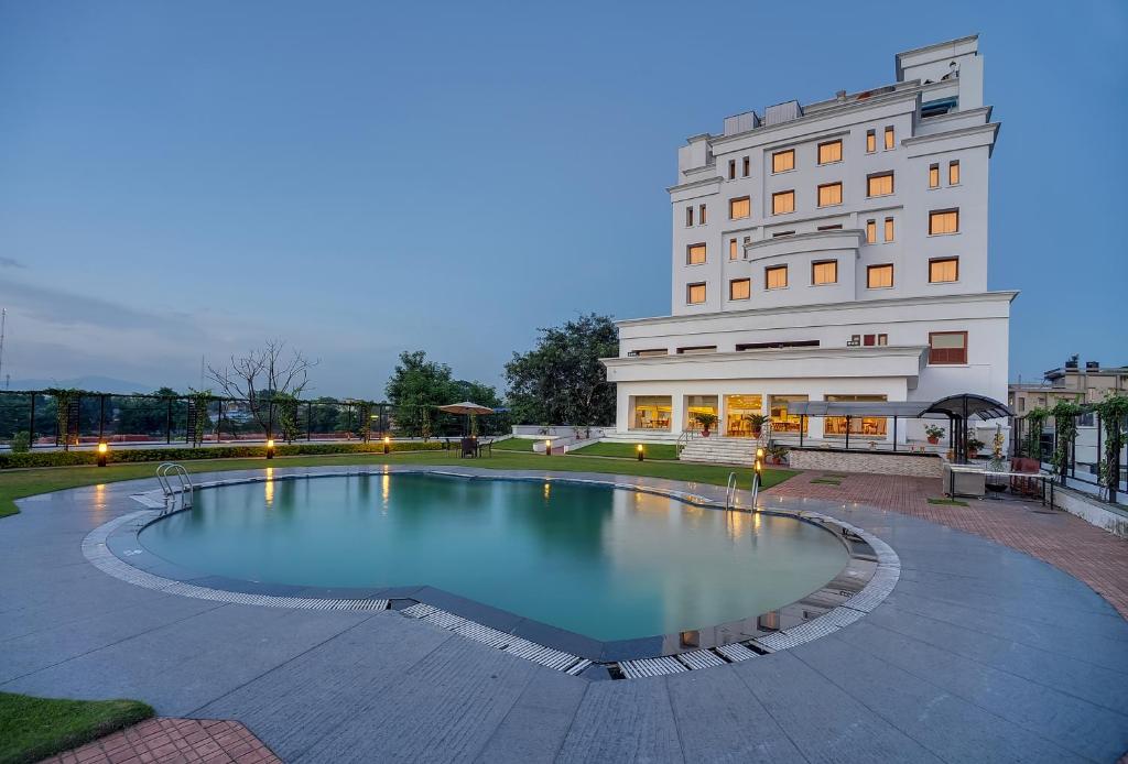 a large swimming pool in front of a building at Royal Sarovar Portico Siliguri in Siliguri