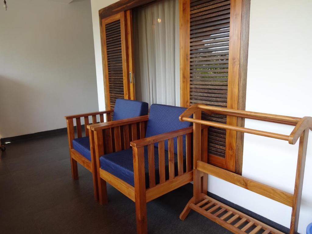 a porch with two chairs and a window at Dunhill Beach Resort in Agonda