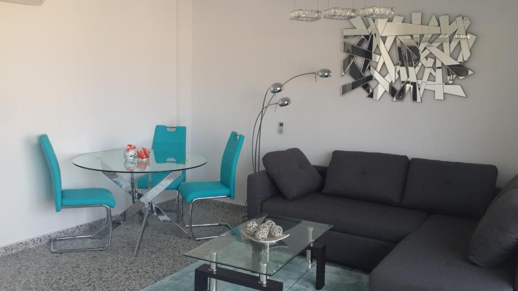 Apartment on Carrer Doctor Sapena في أليكانتي: غرفة معيشة مع أريكة وطاولة وكراسي