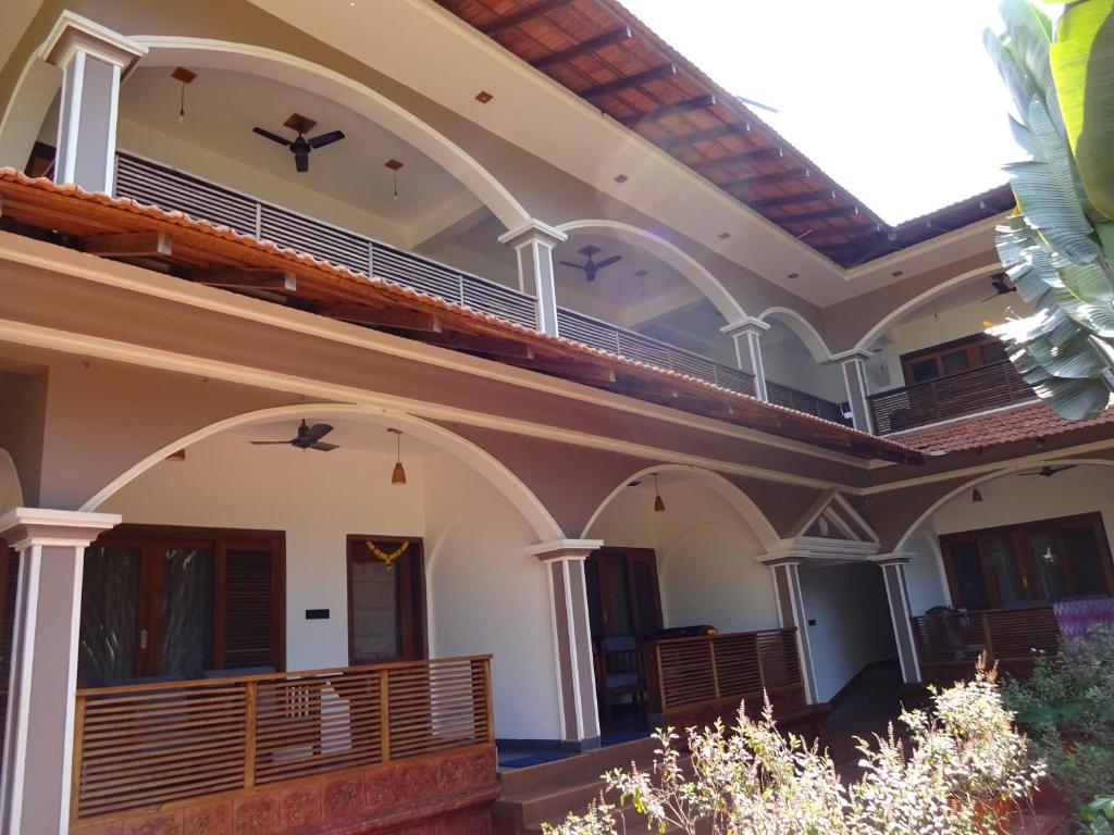 a large building with arches and a balcony at Dunhill Beach Resort in Agonda