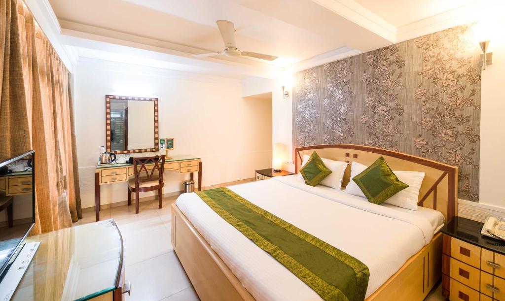 a bedroom with a bed and a desk in a room at Treebo Trend Paradise in Ahmedabad