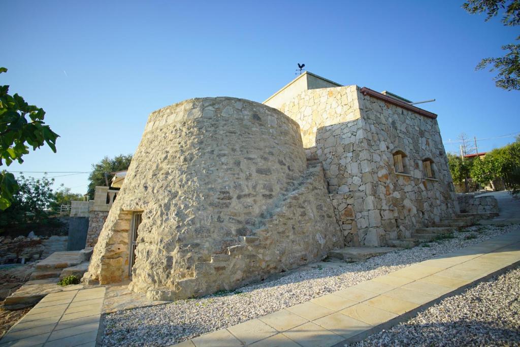 un edificio in pietra seduto sopra un marciapiede di Villa Le Macchie a Torre Vado