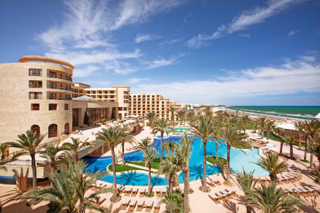 a view of the resort with palm trees and the beach at Mövenpick Resort & Marine Spa Sousse in Sousse