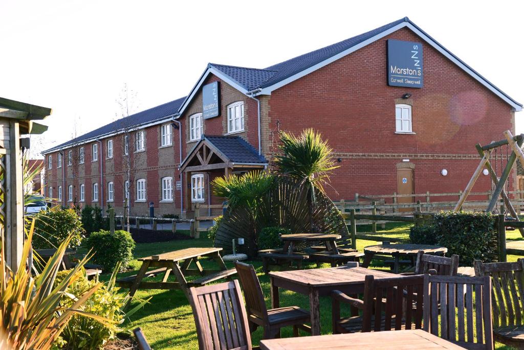 um grupo de mesas e cadeiras em frente a um edifício em Woodcocks, Lincoln by Marston's Inns em Lincoln