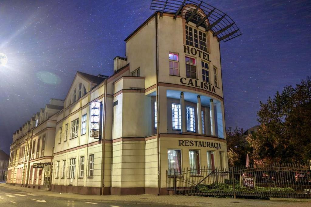 un grand bâtiment avec un panneau à l'avant dans l'établissement Hotel Calisia, à Kalisz