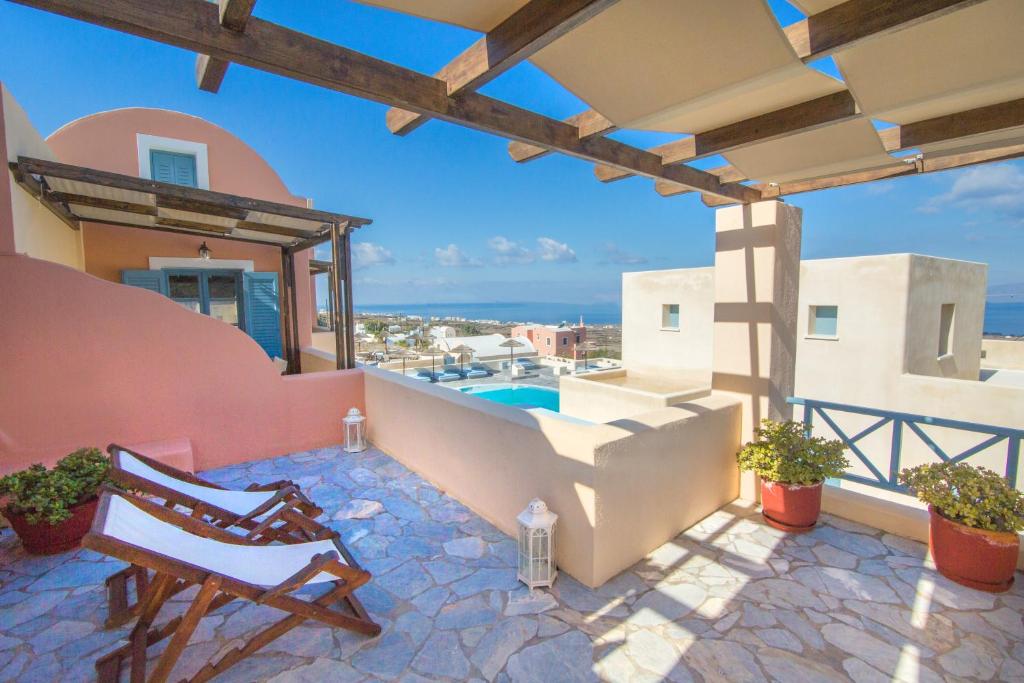 a patio with a chair and a swimming pool at Anemoessa Villa in Oia