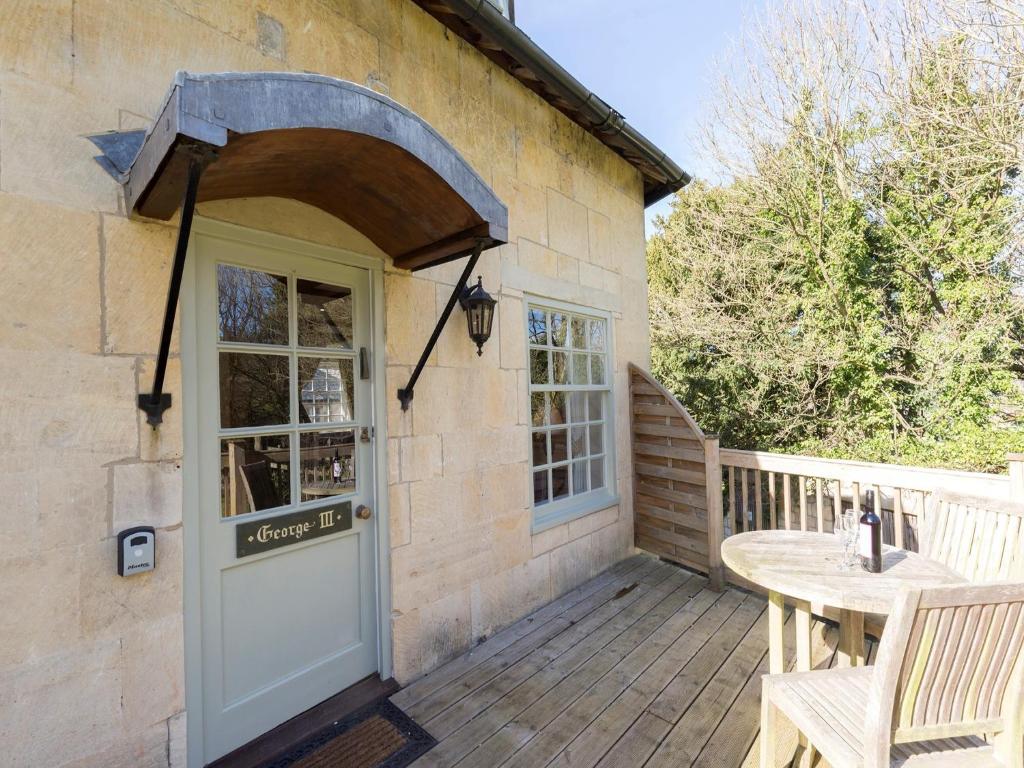 a wooden porch with a door and a table at George III in Winchcombe