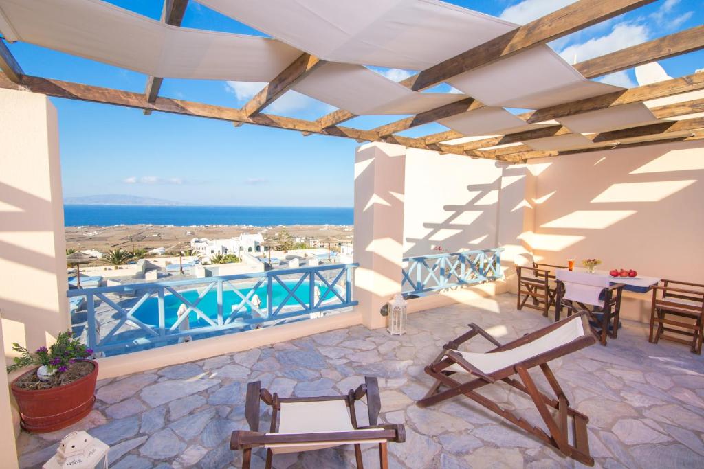 a patio with chairs and a view of the ocean at Anemoessa Villa in Oia