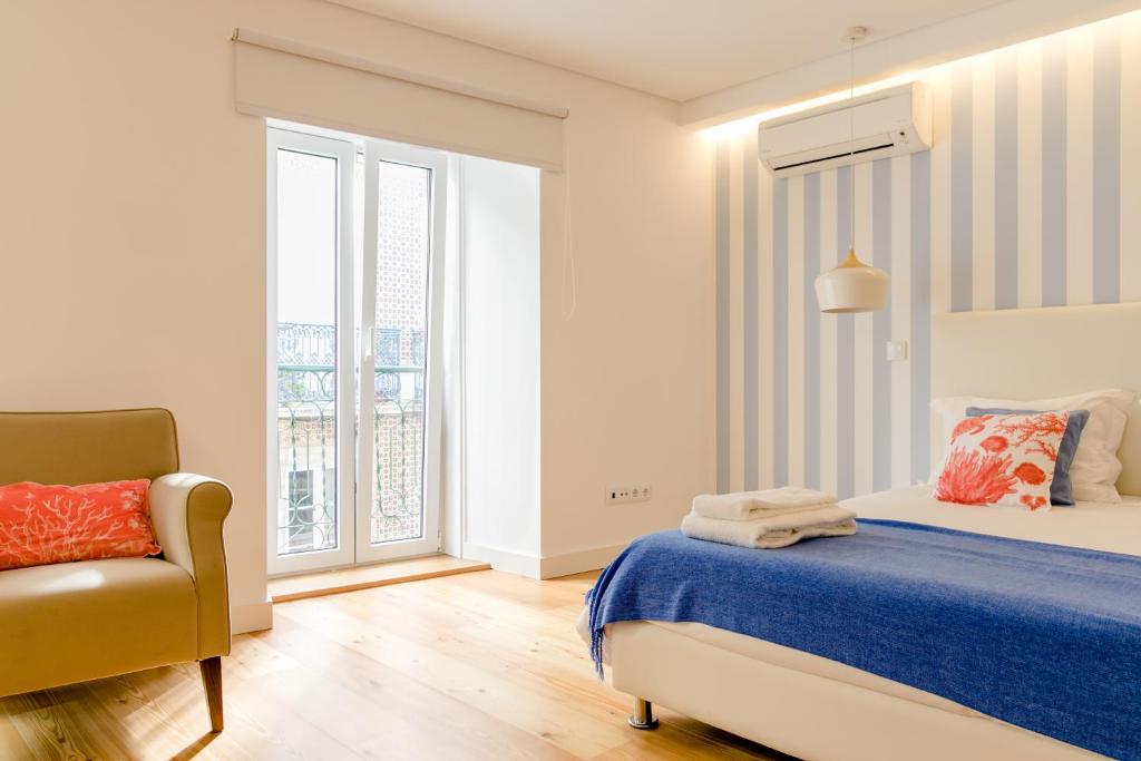 - une chambre avec un lit, une chaise et une fenêtre dans l'établissement Loving Chiado, à Lisbonne