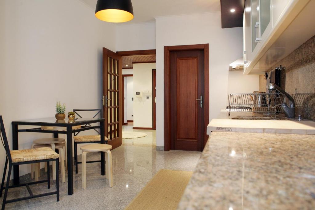 a kitchen with a table and a dining room at Parque das Nações - Fil Pool Apartment in Lisbon