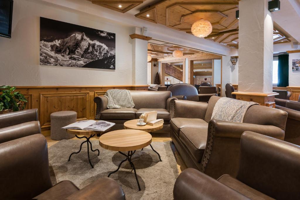 a waiting room with couches and chairs and a table at Hotel le Petit Dru in Morzine