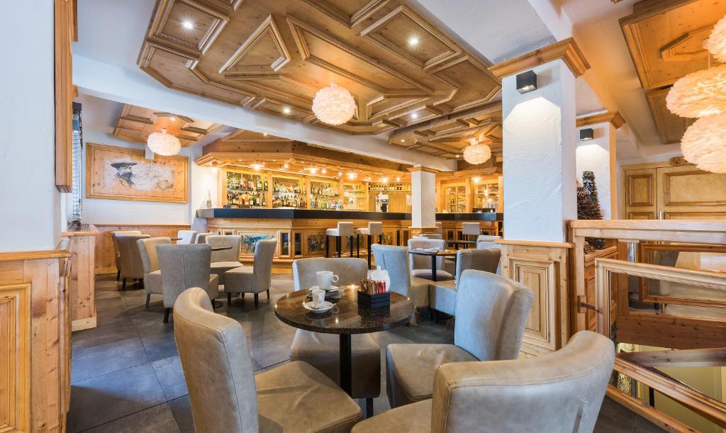 a restaurant with a table and chairs and a bar at Hotel le Petit Dru in Morzine