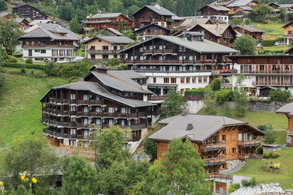 a group of houses on a hill in a village at Hotel le Petit Dru in Morzine