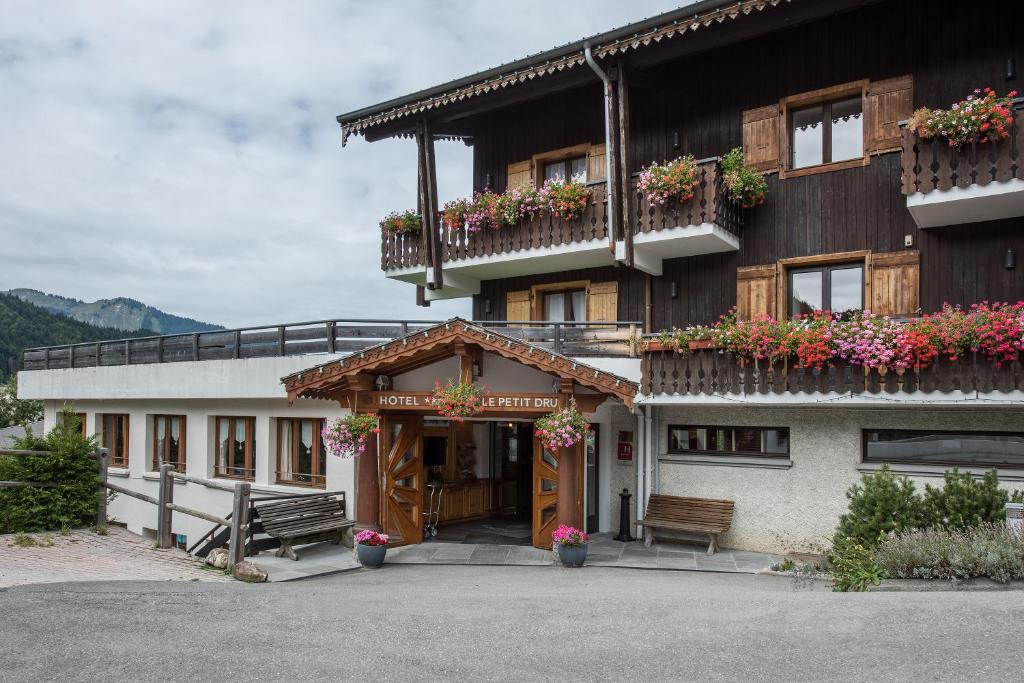 a building with flowers on the balconies of it at Hotel le Petit Dru in Morzine