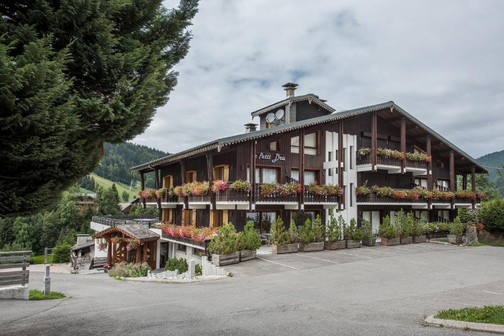 a large building with flowers in front of it at Hotel le Petit Dru in Morzine