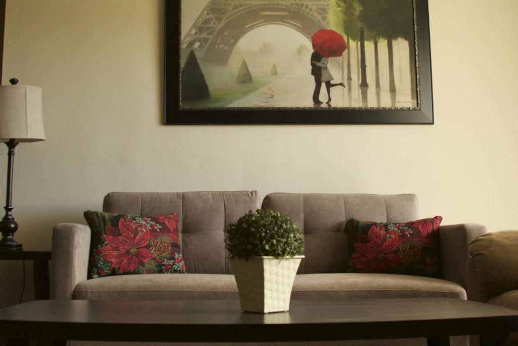 una sala de estar con sofá y una foto de una mujer con sombrilla en Casa De Pedro en Mangilao