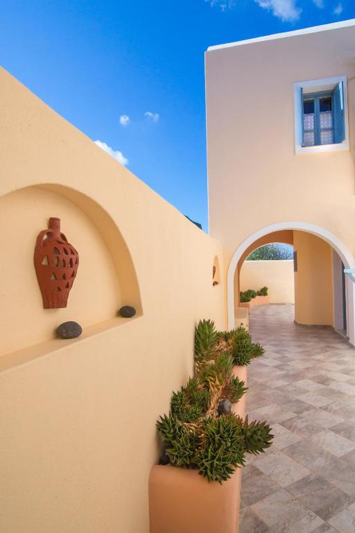 a hallway of a house with a vase on the wall at Anemoessa Villa in Oia