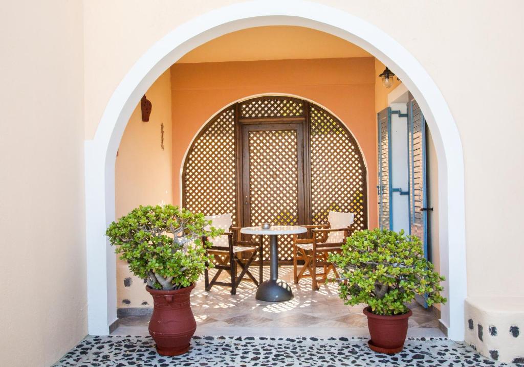 an archway with a table and chairs in a restaurant at Anemoessa Villa in Oia