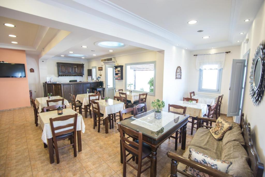 a dining room with tables and chairs and a room with tables and chairsktop at Anemoessa Villa in Oia