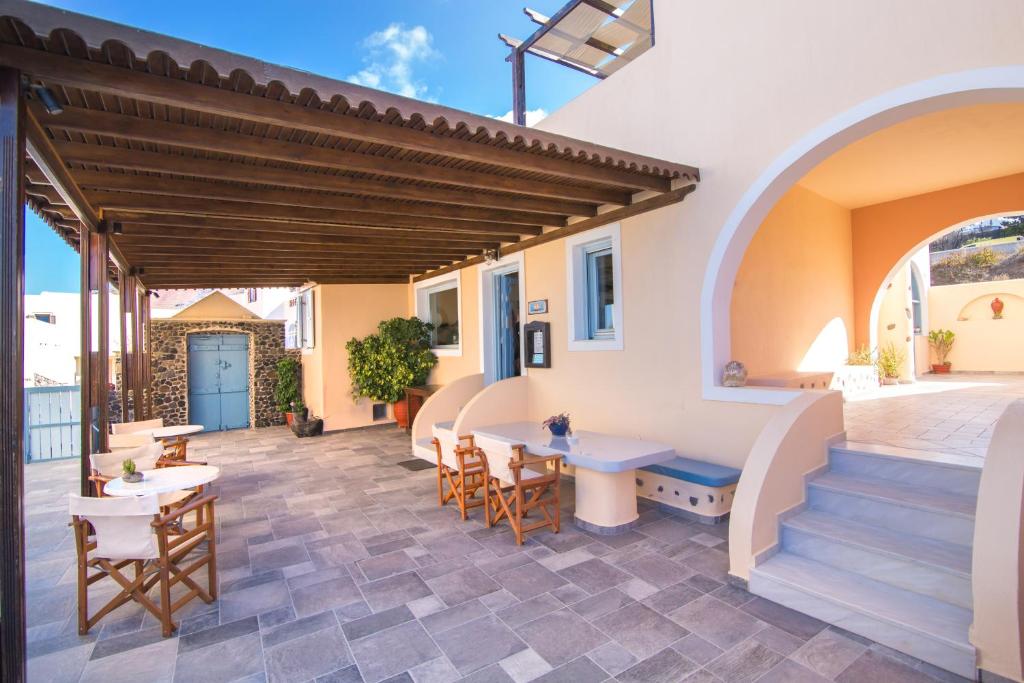 an outdoor patio with a table and chairs at Anemoessa Villa in Oia