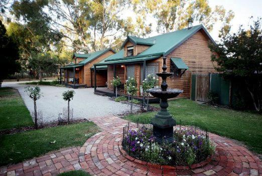 a house with a fountain in front of a house at Cottages on Edward in Deniliquin