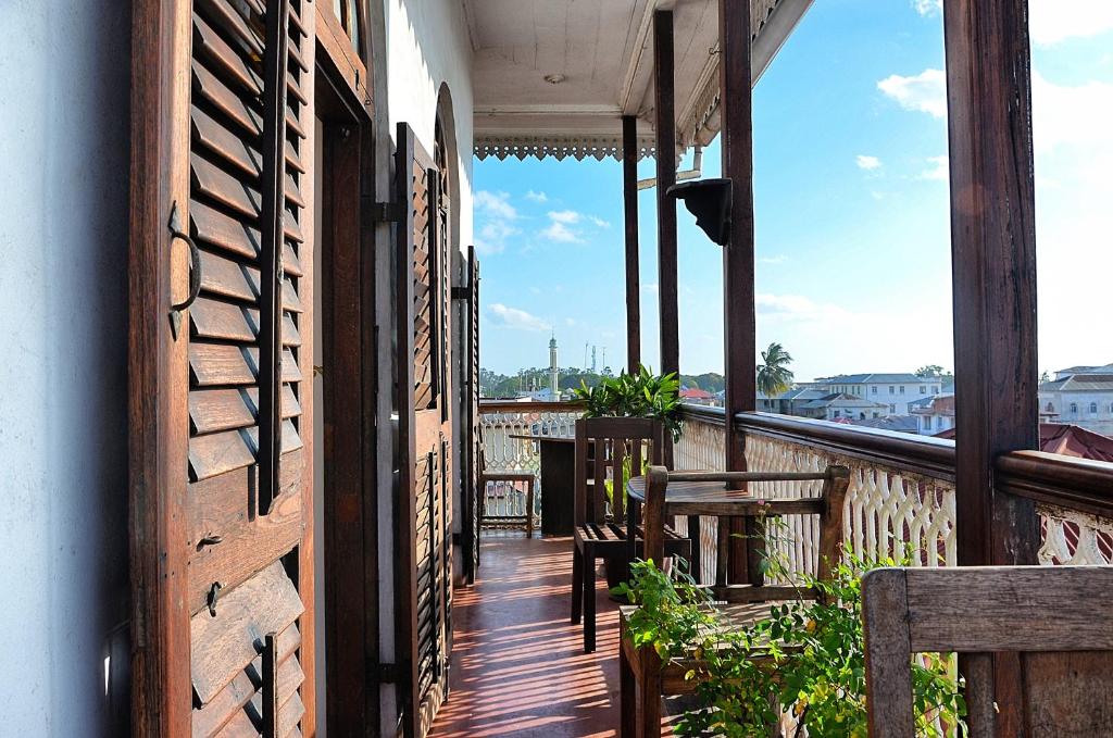 un balcone con tavoli e sedie in un edificio di Zanzibar Coffee House a Zanzibar City