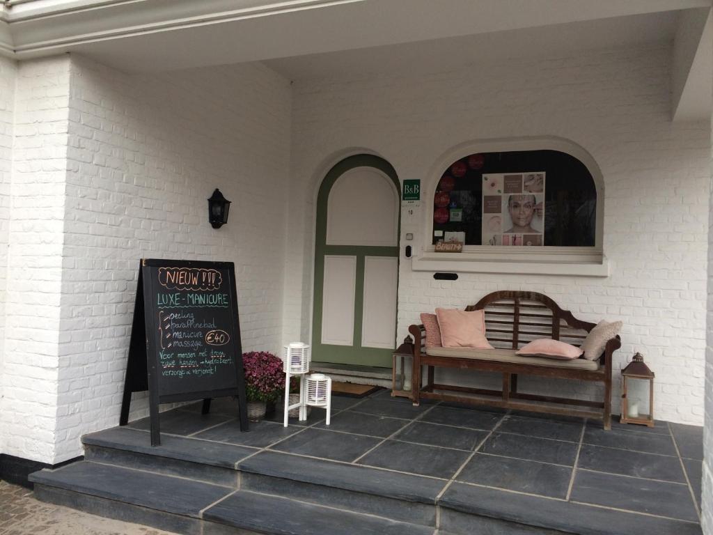 a porch with a bed and a sign on it at Bed & Breakfast Esprit de Mer in De Panne