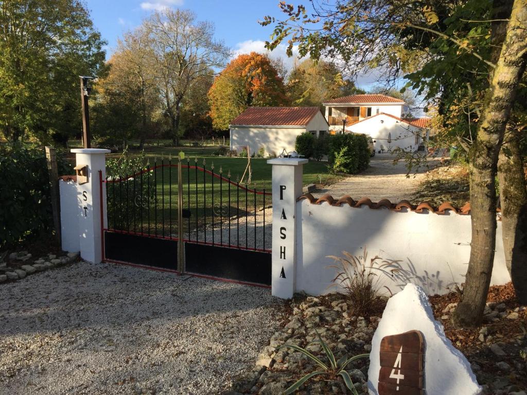 una cerca blanca con una puerta en un patio en St Pasha en Paillé