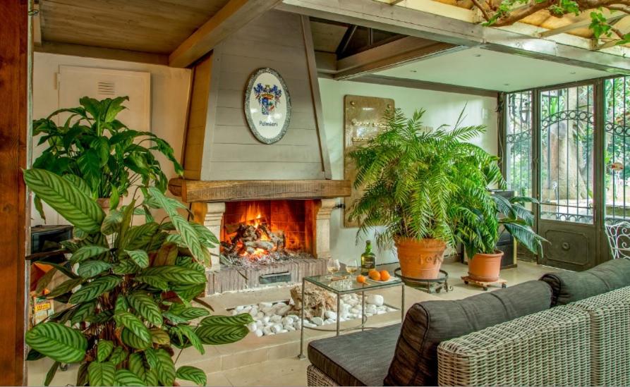 a living room with a fireplace and plants at Antica Locanda Palmieri in Rome