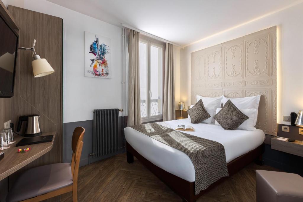 una camera d'albergo con letto e finestra di Contact Hôtel Alizé Montmartre a Parigi