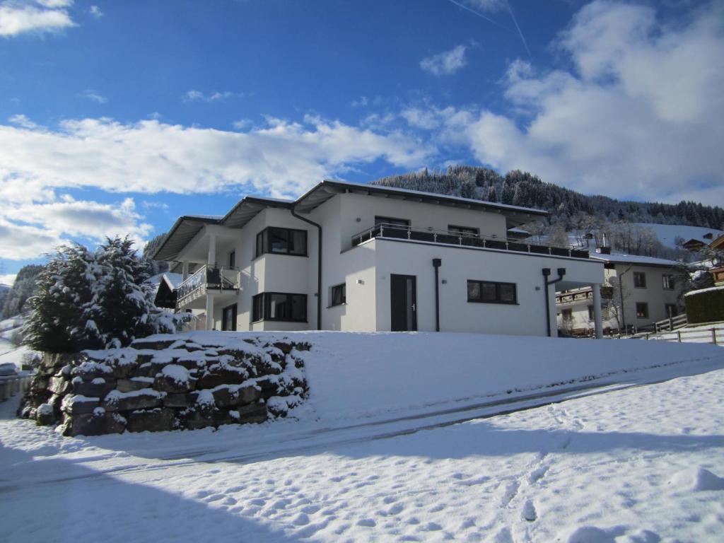 a house with snow in front of it at Appartementhaus Gretzel in Wagrain