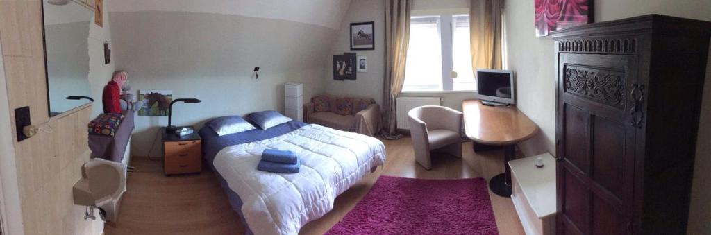 Schlafzimmer mit einem Bett, einem Schreibtisch und einem Stuhl in der Unterkunft Villa Estee in De Haan