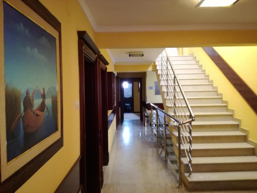 a hallway with stairs and a painting on the wall at Hotel Mimoza in Budva