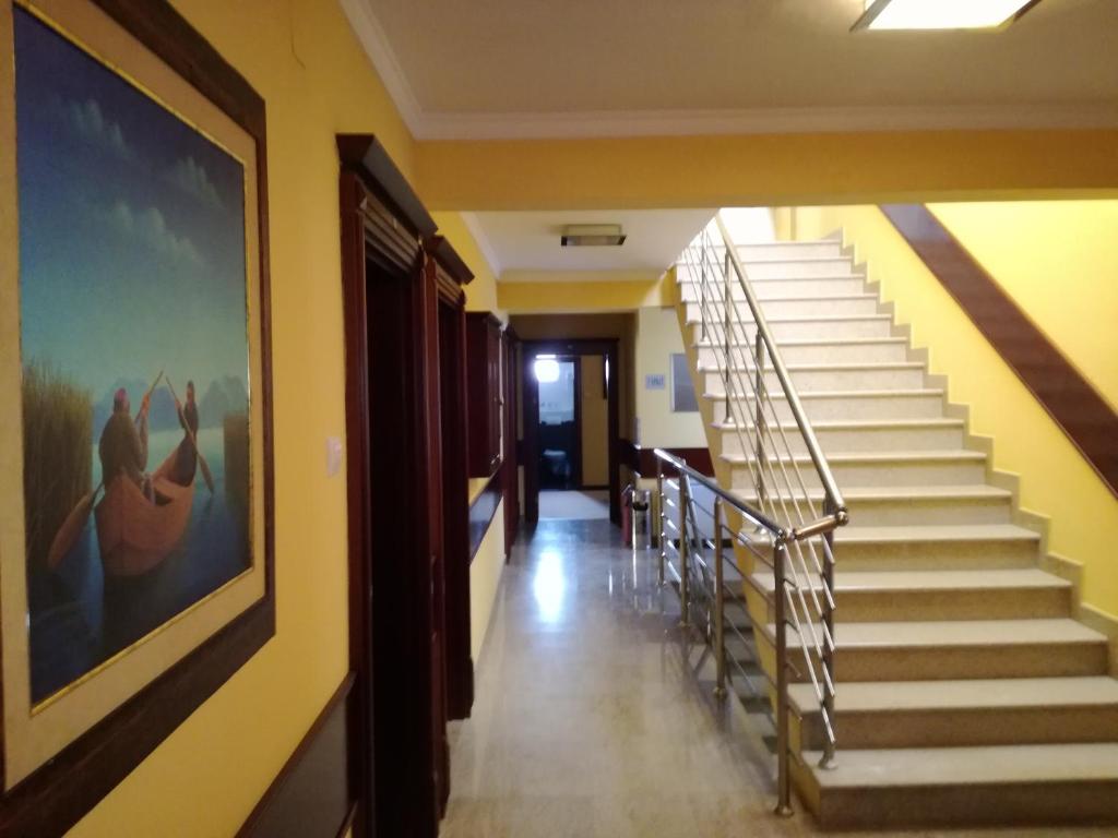 un pasillo con escaleras y una pintura en la pared en Hotel Mimoza, en Budva