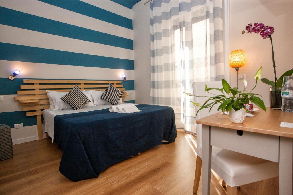 - une chambre avec un lit à rayures bleues et blanches dans l'établissement B&B Kalavrìa, à Reggio de Calabre