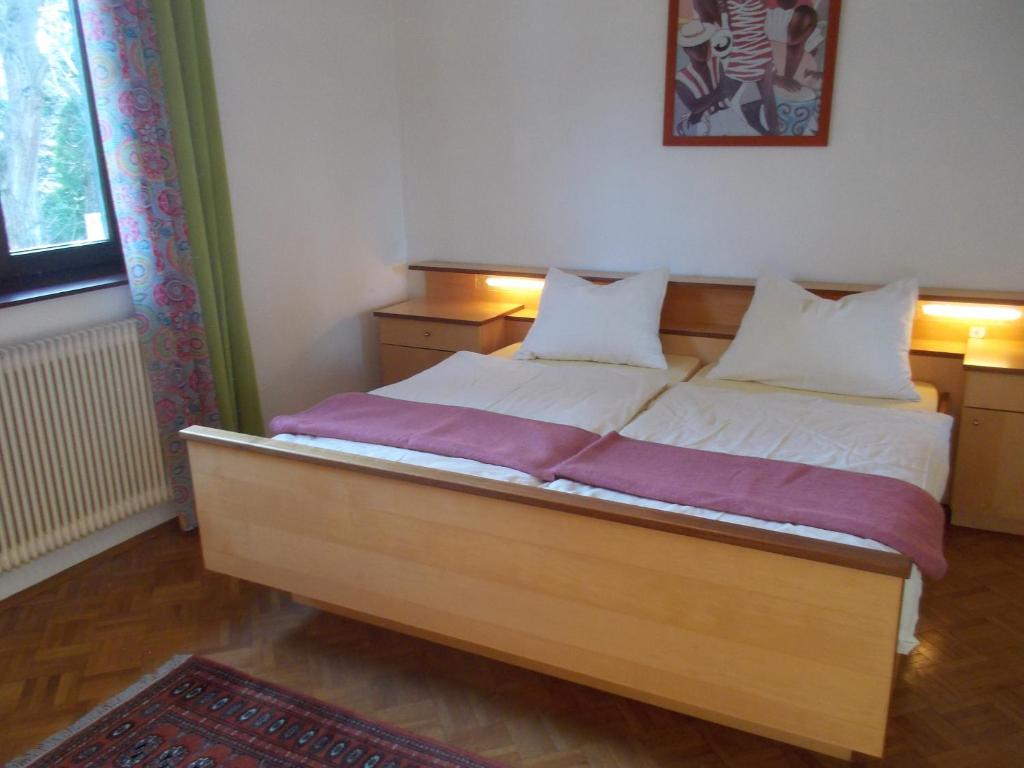 a bedroom with a wooden bed with two pillows at Walnut Tree House in Neulengbach