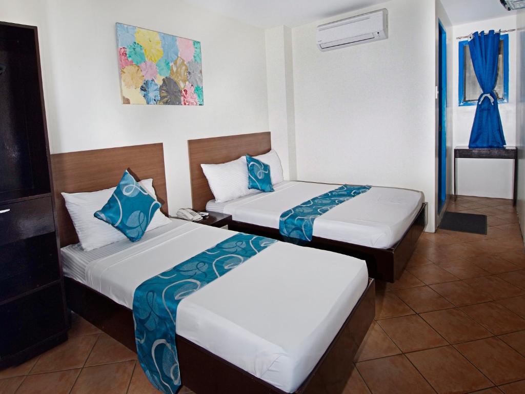 Postel nebo postele na pokoji v ubytování Skyblue Hotel