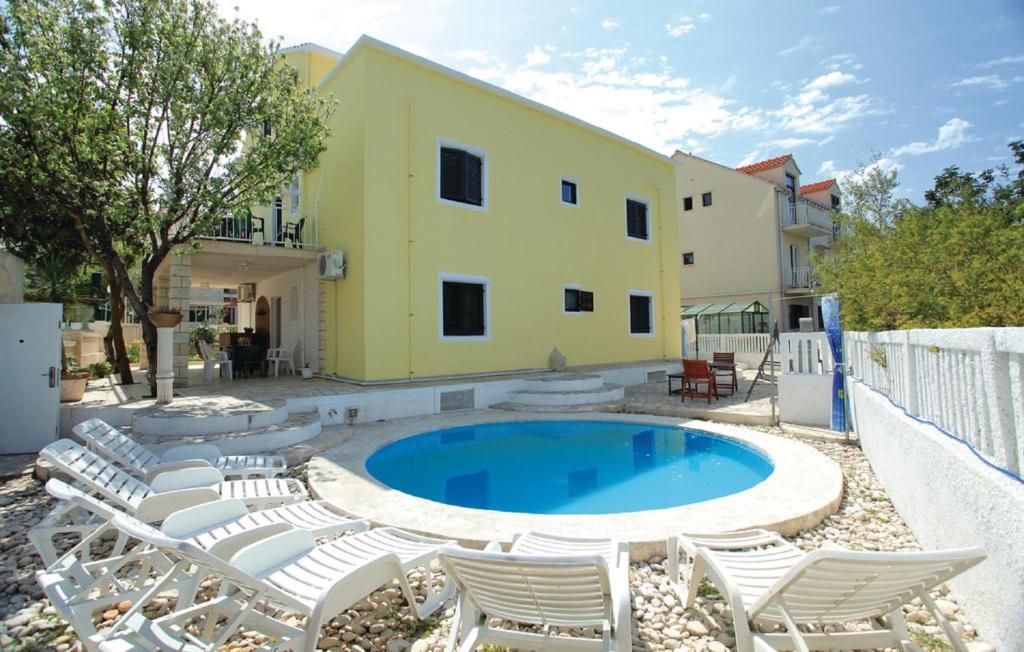 a swimming pool with chairs and a building at Dragan's Den Hostel in Korčula