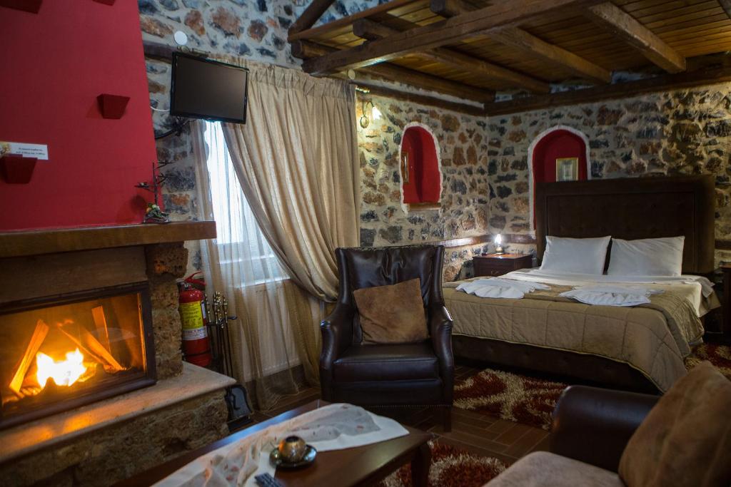 Habitación de hotel con cama y chimenea en Guesthouse Elati - Pella, en Palaios Agios Athanasios