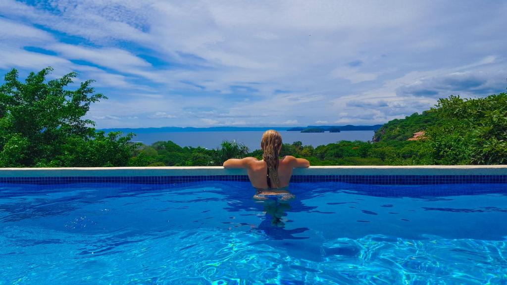 uma mulher sentada na água numa piscina em Pura Vista Hotel em Ocotal