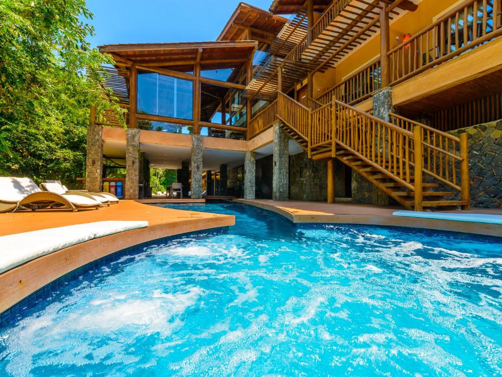 uma casa com uma grande piscina com uma escadaria em Kalango Hotel Boutique em Ilhabela