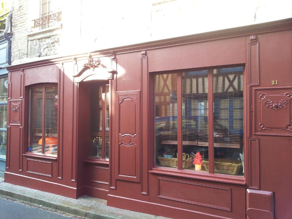 翁弗勒爾的住宿－La Maison de Honfleur，街道上装有窗户的红色商店前