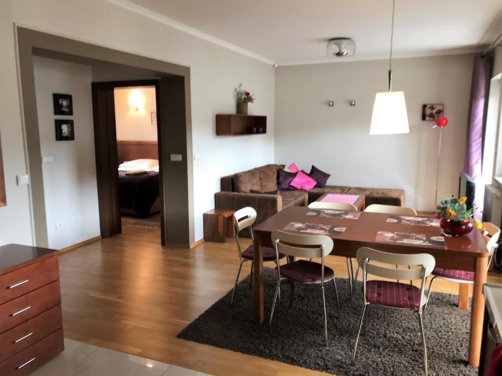 a kitchen and living room with a table and chairs at Bystra Woda Apartament Słoneczny in Zakopane