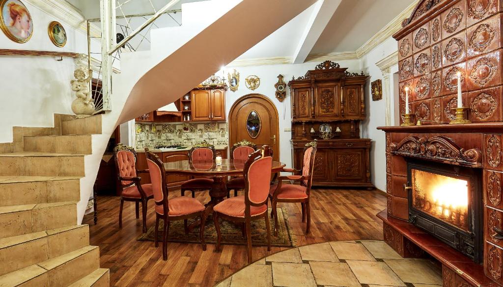 une salle à manger avec une table, des chaises et une cheminée dans l'établissement Straszny Dwór, à Zakopane