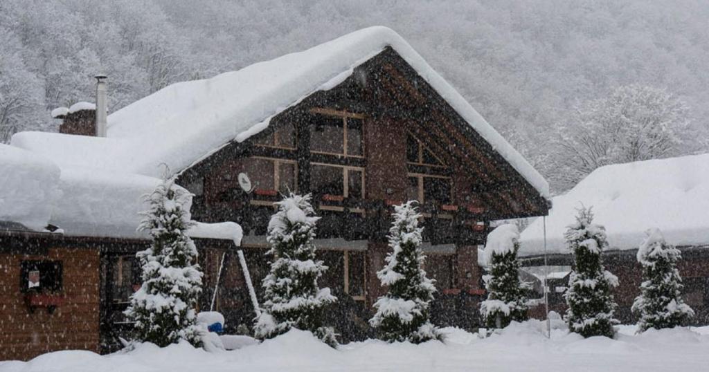 エストサドクにあるCottages Homutovskiy Dvorikの雪に覆われた家