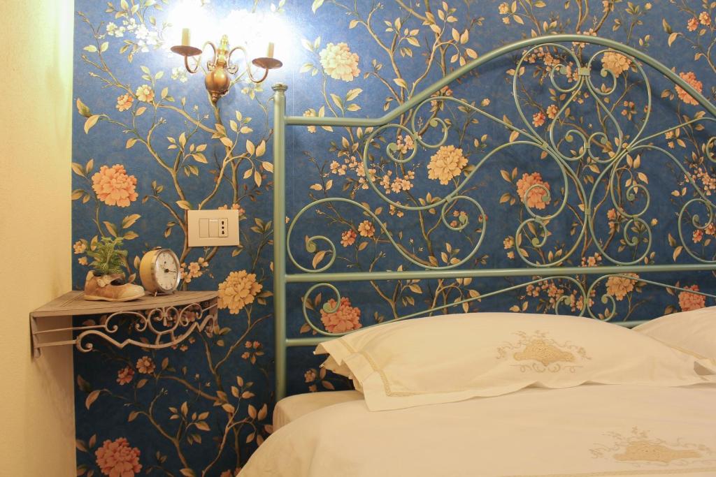 a bedroom with a blue and gold floral wallpaper at Jacaranda in Cagliari