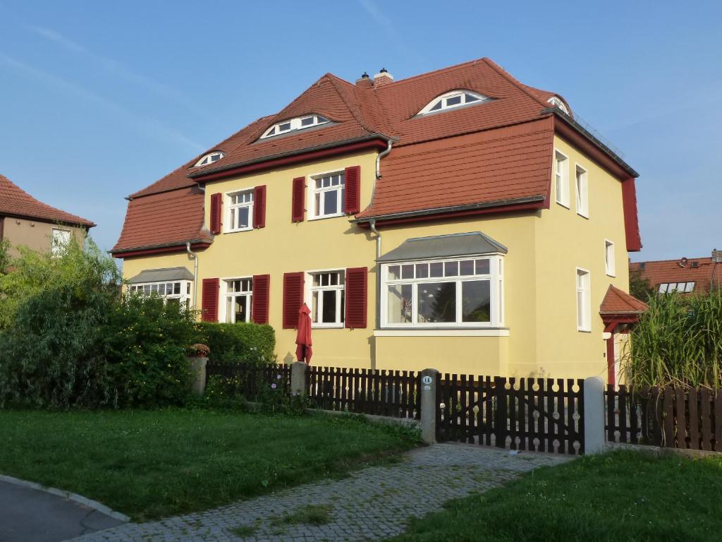 una casa amarilla con techo marrón en Ferienwohnung Hohaus Dresden, en Dresden