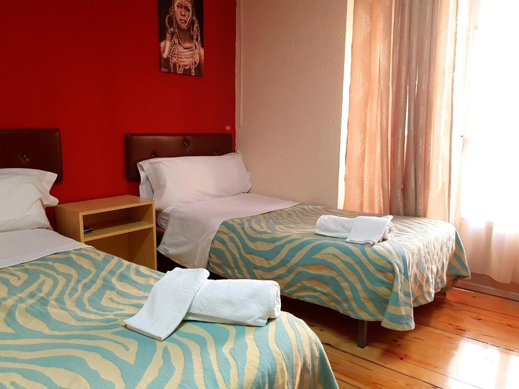 Habitación con 2 camas y toallas. en Hostal Padre Isla 1 en León